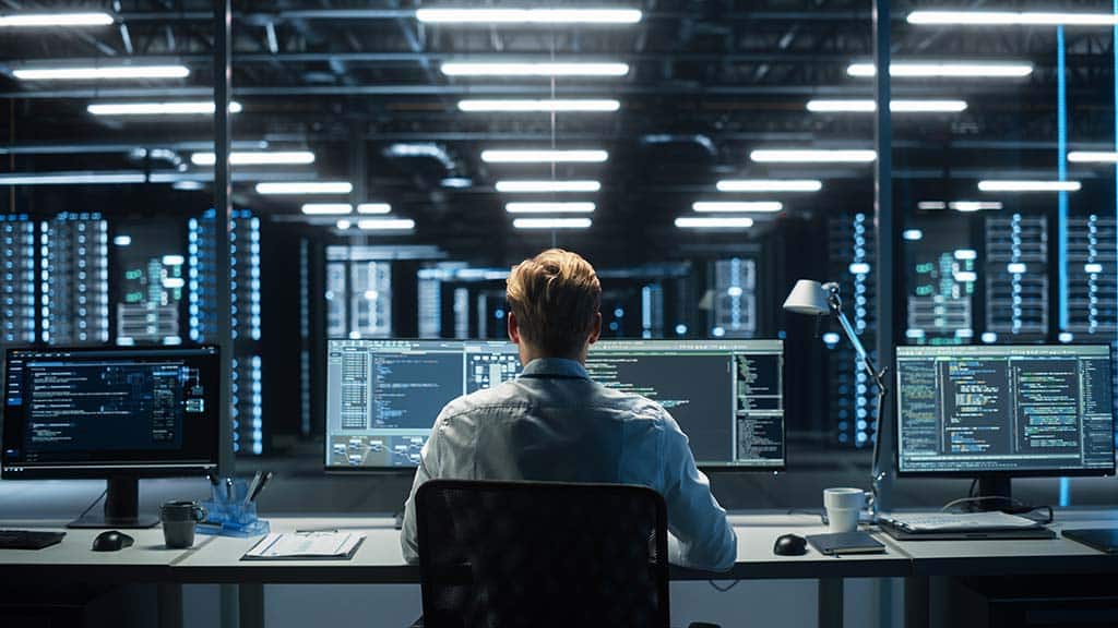 A technical operator monitors displays in a data center.