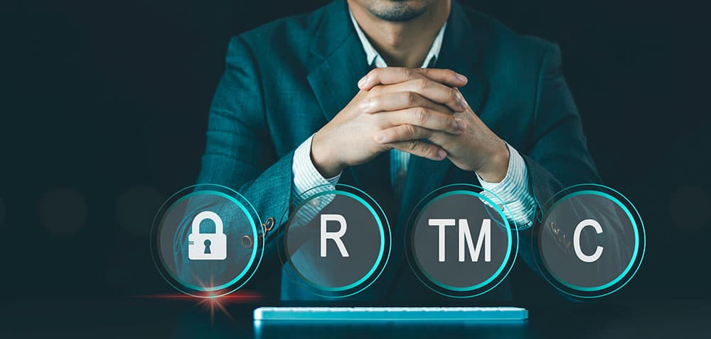A businessman sits behind a row of icons representing different types of IP protection.